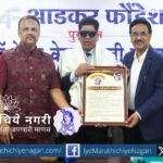 रवी वाघ यांना डॉ. हेलन केलर स्मृती पुरस्कार देताना प्रा. मिलिंद जोशी आणि मंचावरील मान्यवर